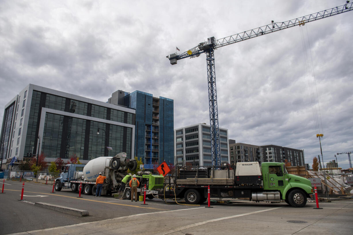 Workers help construct the future parking garage at the corner of Columbia Way and Esther Street in The Waterfront Vancouver on Thursday afternoon, Oct. 21, 2021.