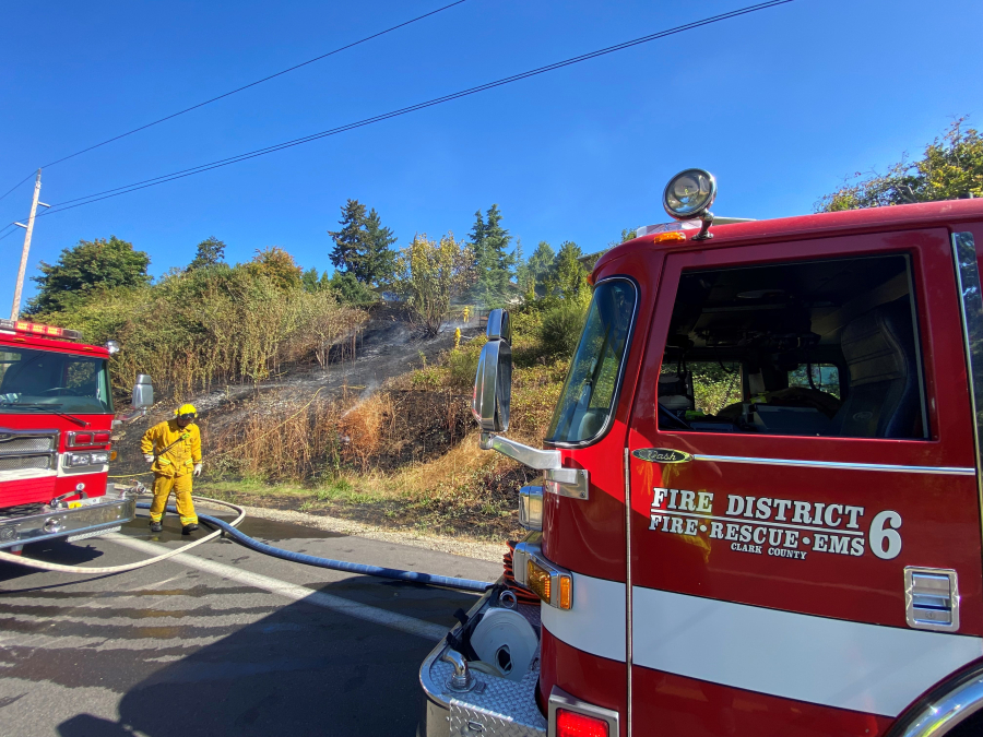Firefighters from Fire District 6 extinguish a brush fire last month above Northwest Lakeshore Avenue. The district is one of four with contested races for commissioner seats in the Nov. 2 election.
