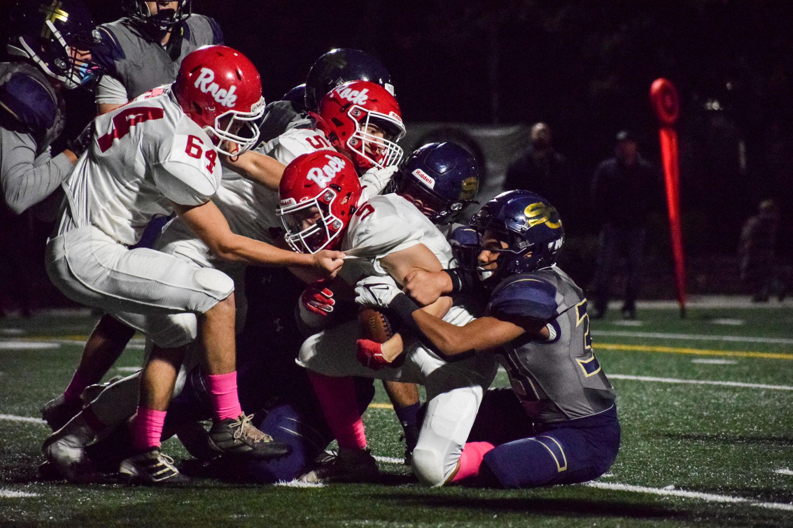 A group of Seton Catholic Cougars try to take down Castle Rock's Chase Rusher (5) while his teammates try to keep him on his feet on Friday.