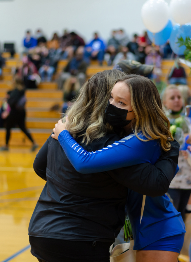 La Center volleyball senior Summer Senske hugs her mother, Sonjuliane Hayes, during a senior night ceremony before a match on Oct. 12 at La Center High School. Senske returned to volleyball this season after her father, Tim, died of COVID-19 in January. The sport connected the two and now Senske grapples with a season without him in the stands.