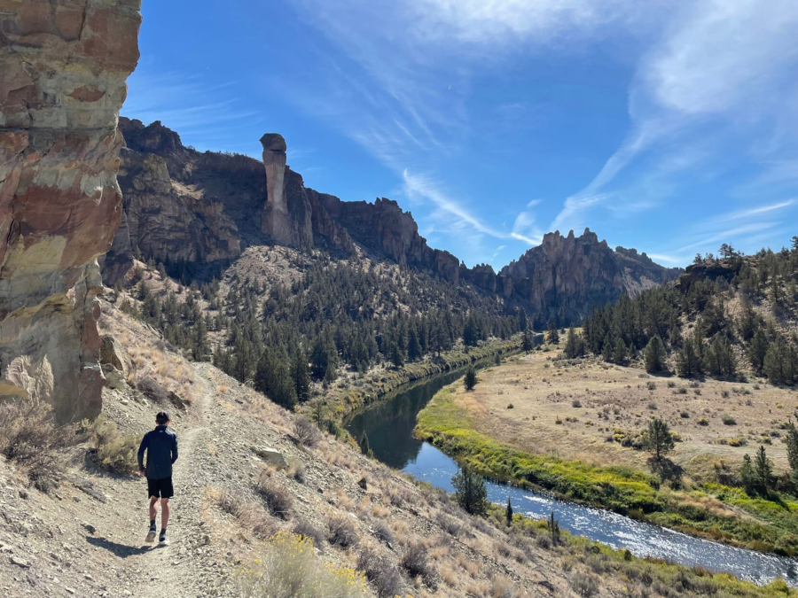 A trail runner navigates the River Trail along the Crooked River at Smith Rock State Park.