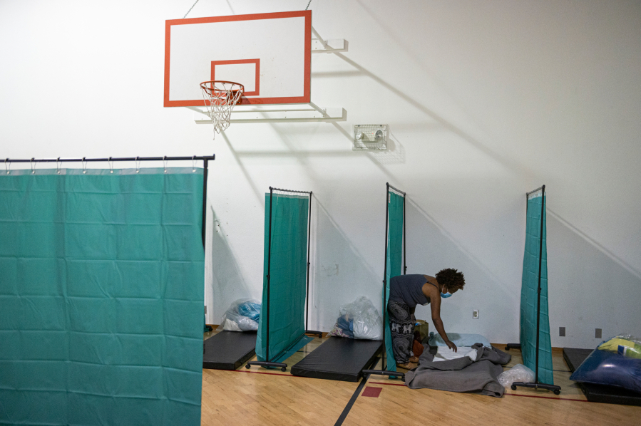 Sleeping areas are separated by shower curtains for sanitary purposes at the Winter Hospitality Overflows's emergency shelters in 2020. They also require guests to wear masks at all times unless they are eating or sleeping.