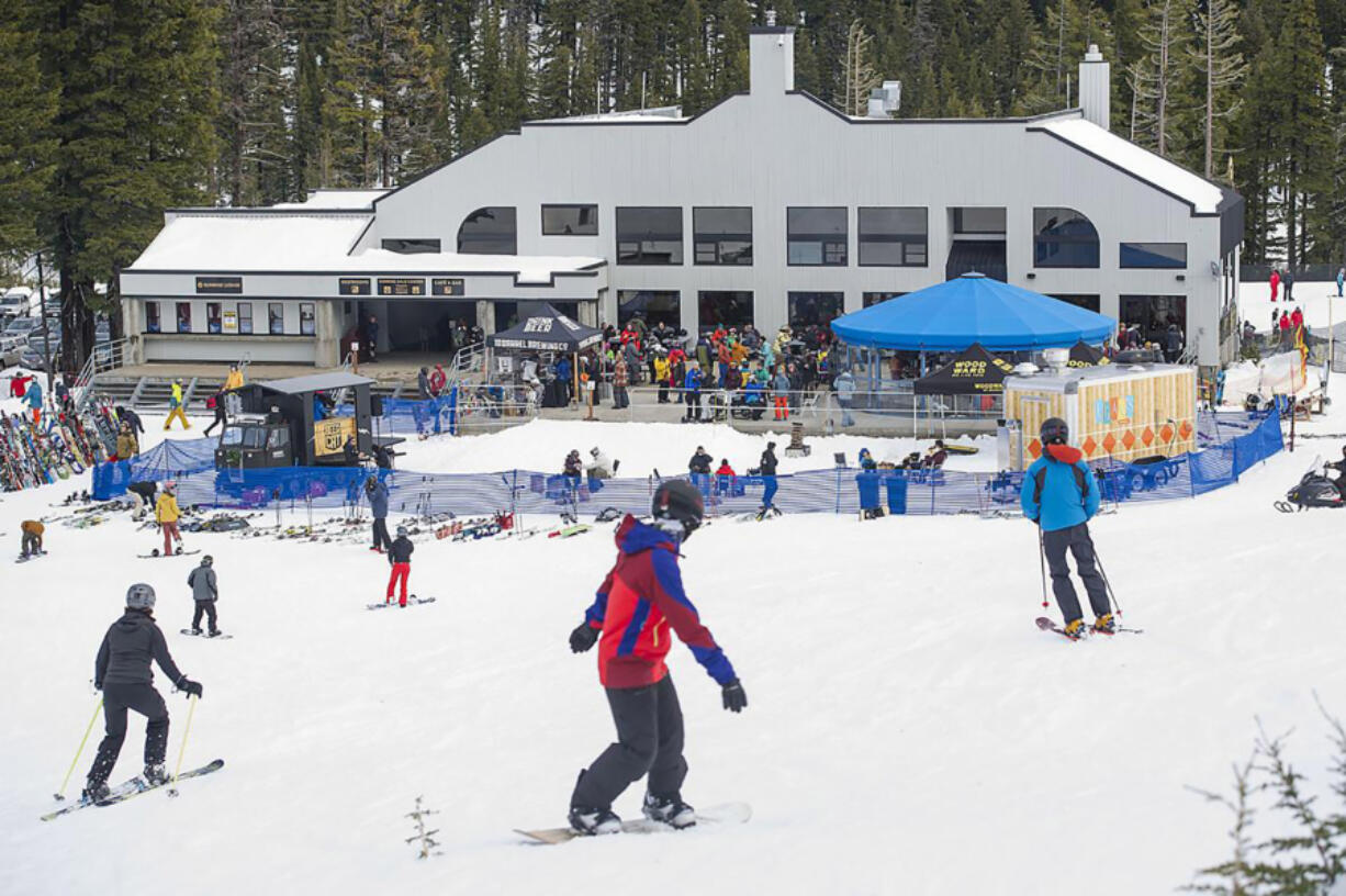 Skiers and snowboarders make their way down the slopes toward Sunrise Lodge at Mt. Bachelor ski area in Oregon in 2019.