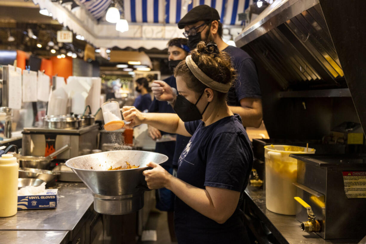 Rebecca Foxman, the owner of Fox & Son, works on seasoning fries for an order at Reading Terminal Market. Foxman pays her team about $20 an hour. She gave out raises after she was awarded an RRF grant ??? money that ultimately never arrived in her bank account.