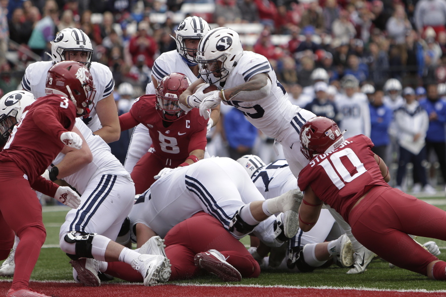BYU running back Tyler Allgeier, top center, reaches for a touchdown during the second half of an NCAA college football game against Washington State, Saturday, Oct. 23, 2021, in Pullman, Wash. BYU won 21-19.