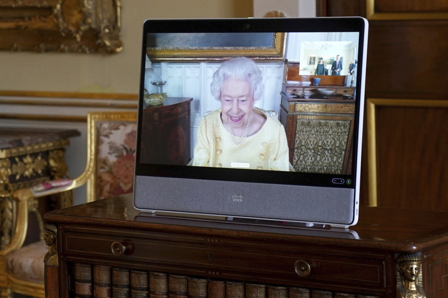 Queen Elizabeth II appears on a screen via videolink from Windsor Castle, where she is in residence, during a virtual audience at Buckingham Palace, London, Tuesday, Oct. 26, 2021.