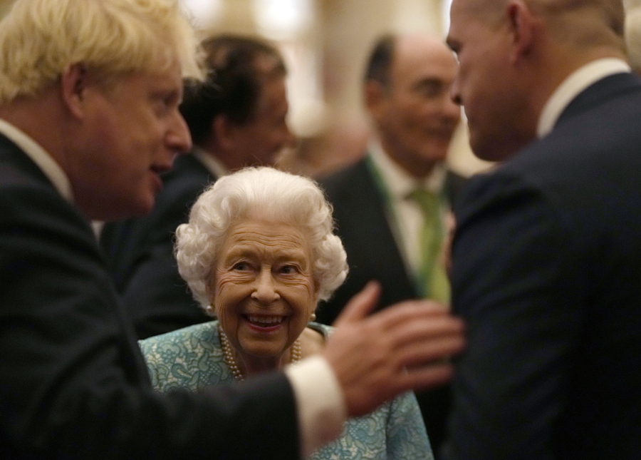 Britain's Queen Elizabeth II and Prime Minister Boris Johnson, left, greet guests at a reception for the Global Investment Summit in Windsor Castle, Windsor, England, Tuesday, Oct. 19, 2021.