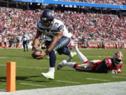 Seattle Seahawks quarterback Russell Wilson (3) runs for a touchdown past San Francisco 49ers defensive tackle Javon Kinlaw (99) during the second half of an NFL football game in Santa Clara, Calif., Sunday, Oct. 3, 2021.