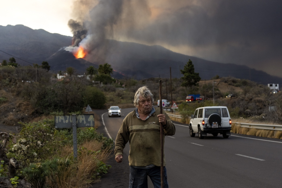 Nemesio, 69, takes his daily walk around his house, near the erupting volcano, on the Canary island of La Palma, Spain, Wednesday, Oct. 27, 2021. Officials say a volcano erupting for the past five weeks on the Spanish island of La Palma is more active than ever. New lava flows have emerged following a partial collapse of the crater and threaten to engulf previously unaffected areas.