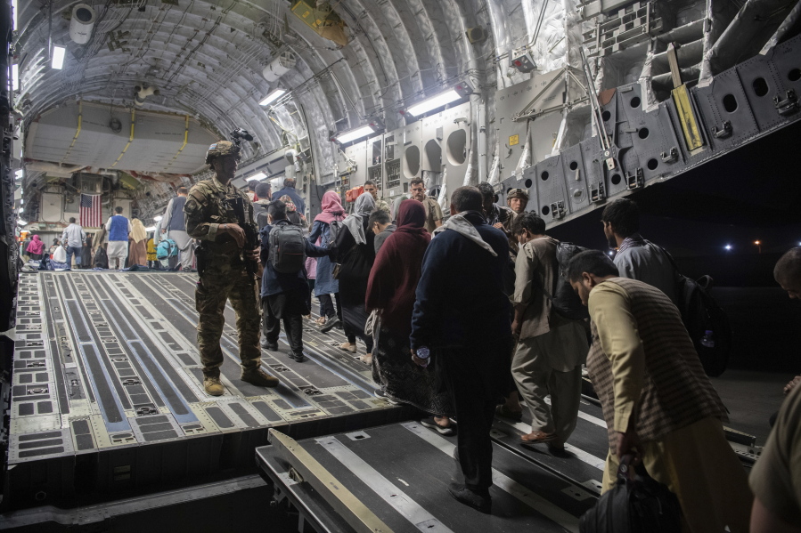 FILE - In this Aug. 22, 2021, file photo provided by the U.S. Air Force, Afghan passengers board a U.S. Air Force C-17 Globemaster III during the Afghanistan evacuation at Hamid Karzai International Airport in Kabul, Afghanistan. An Afghan man who worked for the U.S. government in Afghanistan says the Biden administration has ignored his pleas for help to evacuate his two young sons from Afghanistan after their mother died of a heart attack while being threatened by the Taliban. The International Refugee Assistance Project on Thursday, Oct. 7, 2021 filed a lawsuit against Secretary of State Antony Bilken on the man's behalf. The father fears for his children's safety and asked that he be identified only by his first name, Mohammad. (MSgt. Donald R. Allen/U.S.
