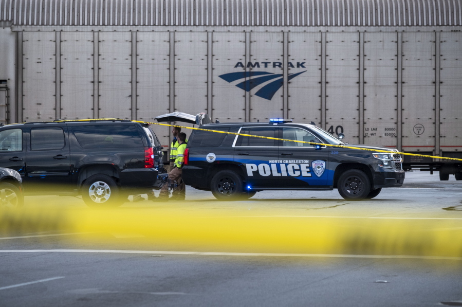 Police work the scene of an early morning collision between a vehicle and a train on Remount Road in North Charleston, S.C. on Saturday, Oct.30, 2021. Authorities say a collision between an Amtrak train and a vehicle at a railroad crossing in South Carolina has resulted in three deaths.
