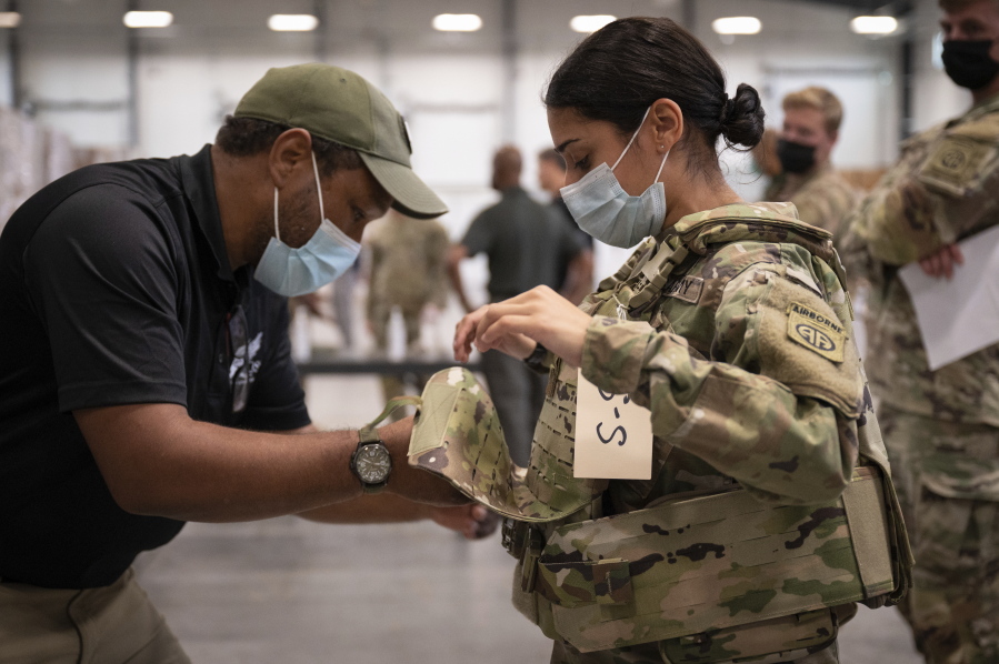 In this image provided by the U.S. Army, Sgt. Katiushka Rivera, a soldier assigned to the 82nd Airborne gets fitted for a modular scalable vest (MSV) during a fielding event in Fort Bragg, N.C., on Sept. 13, 2021. The Army for the first time, began handing out armor that now comes in three additional sizes, and can be adjusted in multiple ways to fit better and allow soldiers to move faster and more freely. The so-called "modular, scalable vest" was is being distributed to soldiers at Fort Bragg, N.C., along with new versions of the combat shirt that are tailored to better fit women, with shorter sleeves and a flare at the bottom where it hits their hips. (Jason Amadi/U.S.