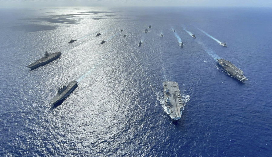 In this photo released by the U.S. Indo-Pacific Command, the United Kingdom's carrier strike group led by HMS Queen Elizabeth (R 08), and Japan Maritime Self-Defense Forces led by (JMSDF) Hyuga-class helicopter destroyer JS Ise (DDH 182) joined with U.S. Navy carrier strike groups led by flagships USS Ronald Reagan (CVN 76) and USS Carl Vinson (CVN 70) sails to conduct multiple carrier strike group operations in the Philippine Sea, Oct. 3, 2021. A spate of recent Chinese military flights off Taiwan, which Beijing claims as its own, and naval maneuvers by the United States and its allies to reinforce maritime routes challenged by China are fueling increasing tensions in a region already on edge. (Gray Gibson/U.S.