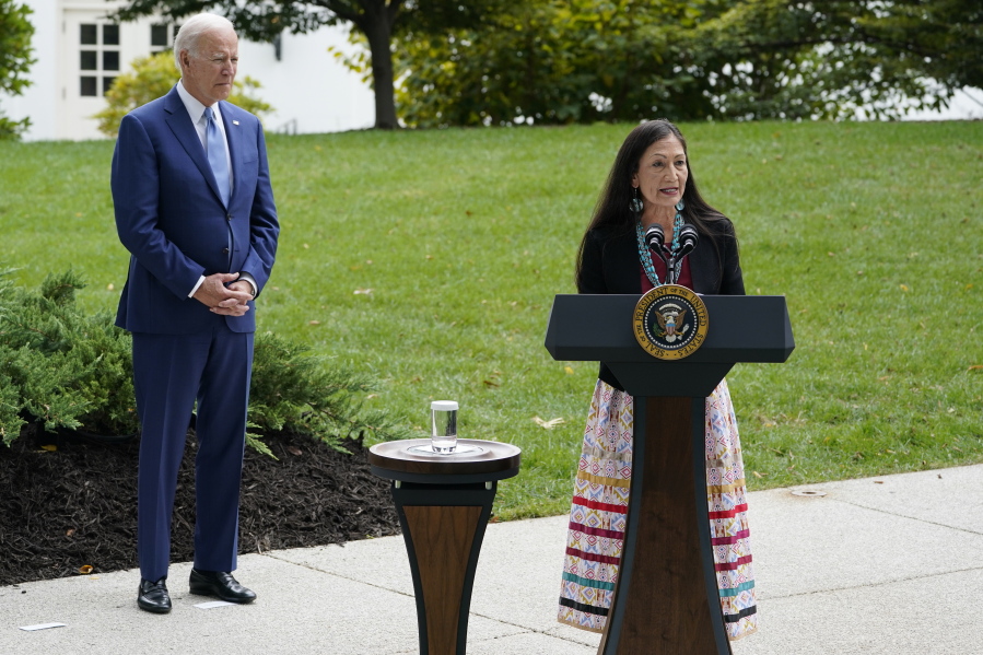 President Joe Biden listens as Interior Secretary Deb Haaland speaks at the White House in Washington, Friday, Oct. 8, 2021, at an event announcing that his administration is restoring protections for two sprawling national monuments in Utah that have been at the center of a long-running public lands dispute, and a separate marine conservation area in New England that recently has been used for commercial fishing.