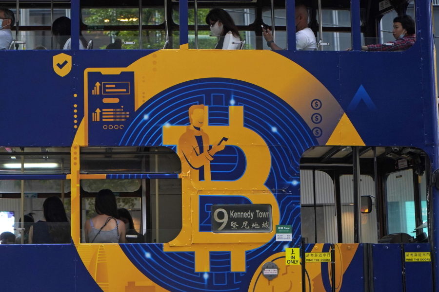 FILE - This May 12, 2021, file photo shows an advertisement for the cryptocurrency Bitcoin displayed on a tram in Hong Kong. Cryptocurrencies have surged to nearly $2.5 trillion in total value, rivaling the size of G7 economies like Canada's and Italy's, with more than 200 million users. At that size, it's simply too large for the financial establishment to ignore. Firms that cater to the world's wealthiest families are increasingly putting some of their fortunes into crypto. Hedge funds are trading Bitcoin, which has big-name banks starting to offer them services around it. And in the latest milestone for the industry, an easy-to-trade fund tied to Bitcoin began trading on Tuesday, Oct. 19, 2021.