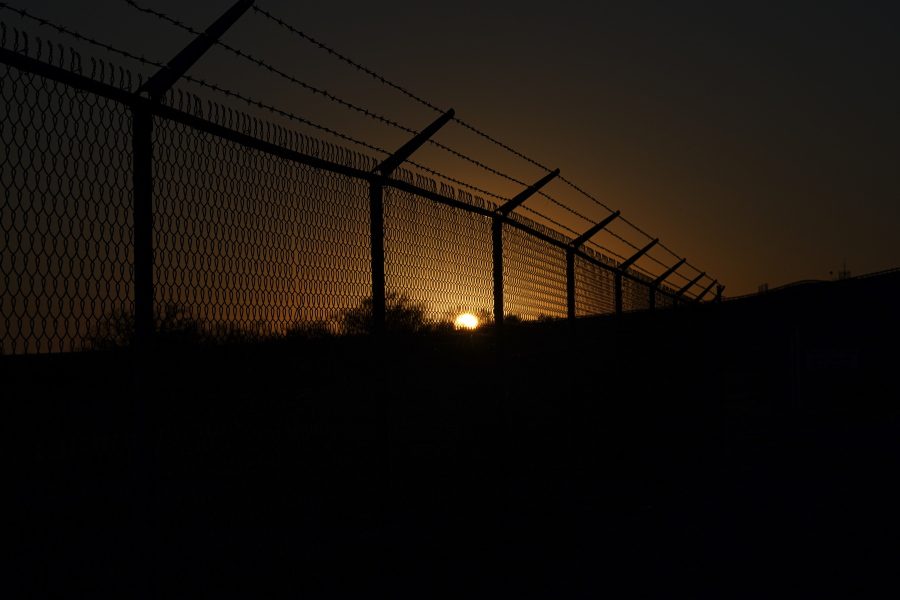 The sun sets behind a border fence separating Del Rio, Texas, and Ciudad Acuna, Mexico, Thursday, Sept. 23, 2021. Each year, the border communities that sit across the Rio Grande from one another come together to celebrate the Fiesta de la Amistad.
