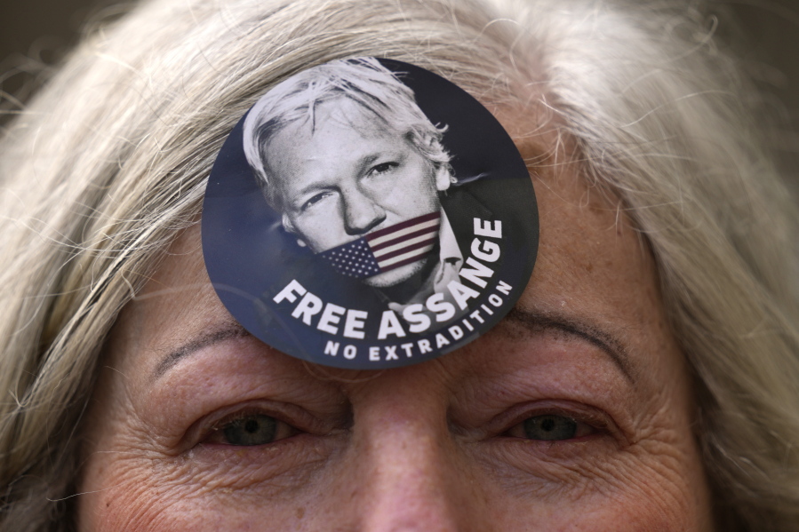 A woman wears a Free Assange badge as supporters of Julian Assange stage a demonstration outside the High Court in London, Wednesday, Oct. 27, 2021. The U.S. government is scheduled to ask Britain's High Court to overturn a judge's decision that WikiLeaks founder Julian Assange should not be sent to the United States to face espionage charges. A lower court judge refused extradition in January on health grounds, saying Assange was likely to kill himself if held under harsh U.S. prison conditions.