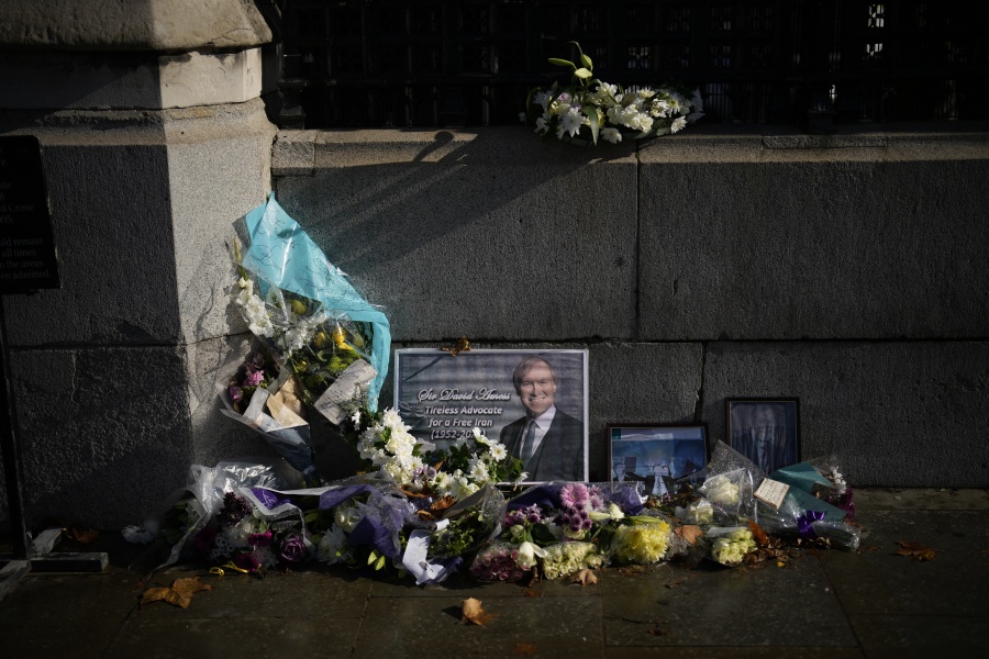 Floral tributes and pictures of Member of Parliament David Amess lie placed outside the Houses of Parliament in London on Wednesday. Amess was stabbed to death Friday during a meeting with constituents in Leigh-on-Sea, England.