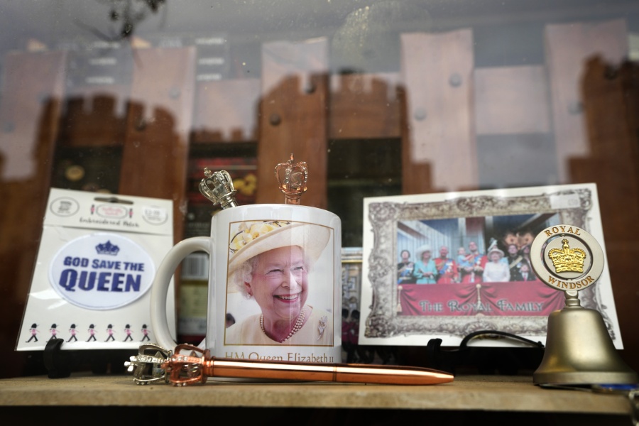 Windsor Castle is reflected in the window of a shop selling Royal souvenirs outside the Castle, in Windsor, England, Friday, Oct. 22, 2021. Britain's Queen Elizabeth II spent a night in a hospital for checks this week after canceling an official trip to Northern Ireland on medical advice, Buckingham Palace said Thursday. The palace said the 95-year-old British monarch went to the private King Edward VII's Hospital in London on Wednesday for "preliminary investigations." It said she returned to her Windsor Castle home at lunchtime on Thursday, "and remains in good spirits.