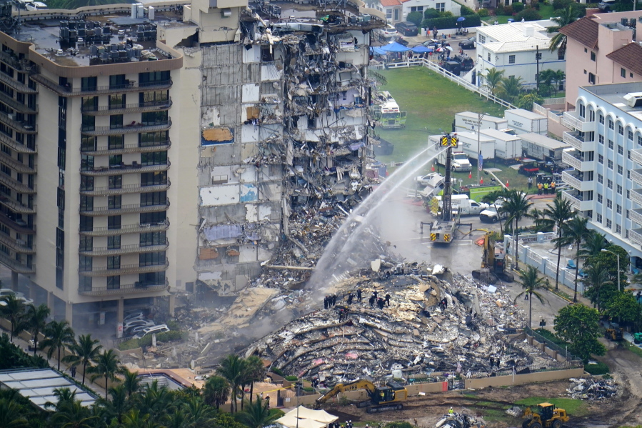 FILE - In this June 25, 2021, file photo, rescue personnel work at the remains of the Champlain Towers South condo building in Surfside, Fla. A judge says a mediator will be named to sort through claims arising from the collapse of a Florida condominium that killed 98 people. Miami-Dade Circuit Judge Michael Hanzman said at a hearing Wednesday, Oct. 6, 2021 that he is hoping to avoid a bitter and lengthy battle over money by victims.
