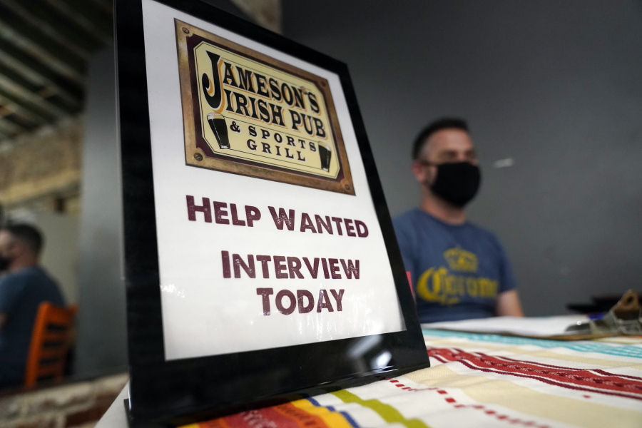 FILE - In this Sept. 22, 2021, file photo, a hiring sign is placed at a booth for Jameson's Irish Pub during a job fair in the West Hollywood section of Los Angeles. California's historic hiring slowed down in September as the state added 47,400 new jobs. California has been averaging more than 100,000 new jobs each month since February. New data released Friday, Oct. 22, 2021, by the U.S. Bureau of Labor Statistics shows California is now tied with Nevada for the highest unemployment rate in the country at 7.5%.