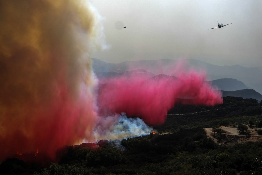 An air tanker drops retardant on a wildfire Wednesday in Goleta, Calif. Firefighters reported Friday the Alisal Fire containment jumped to 41 percent. Officials reopened U.S. 101, the region's main highway, and a rail line that runs next to the highway, Thursday. (Ringo H.W.