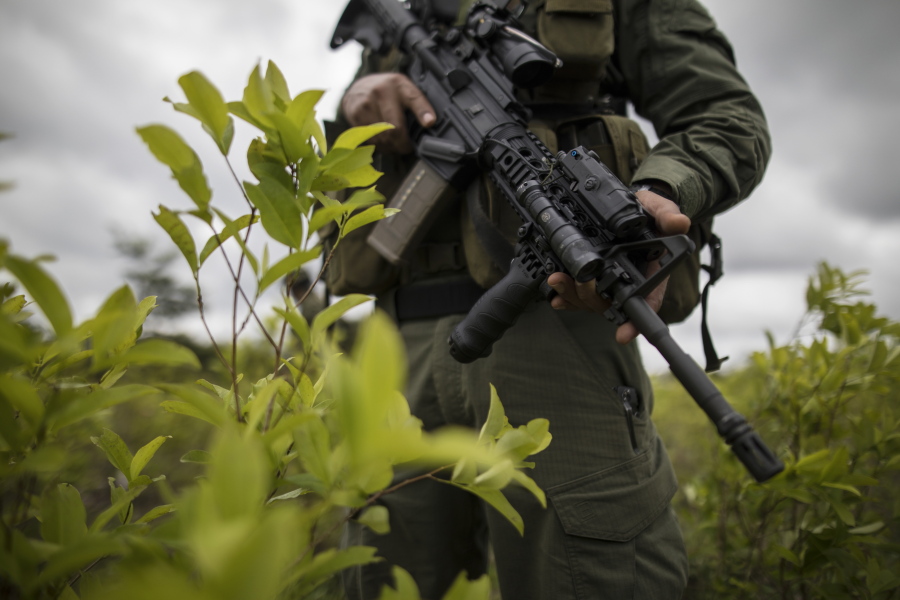 FILE - In this Dec. 30, 2020 file photo, a police officer stands on a coca field during a manual eradication operation in Tumaco, southwestern Colombia. Mosquera facing up to 20 years in a federal U.S. prison for allegedly betraying the Drug Enforcement Administration to the same drug traffickers they were jointly fighting.