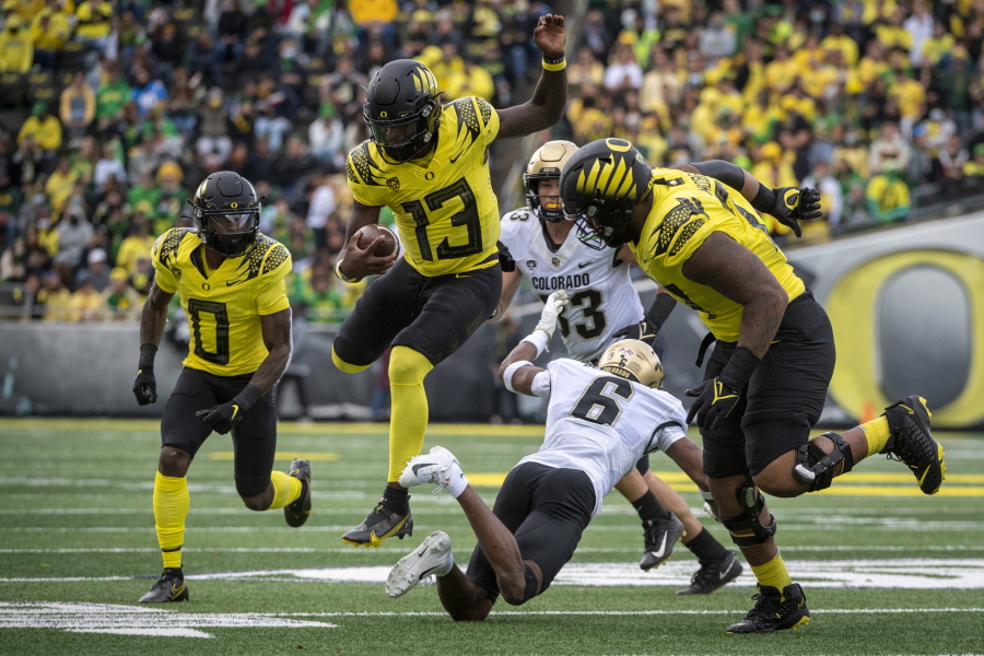 Oregon quarterback Anthony Brown (13) eludes a tackle by Colorado cornerback Mekhi Blackmon (6) during the third quarter of an NCAA college football game Saturday, Oct. 30, 2021, in Eugene, Ore.