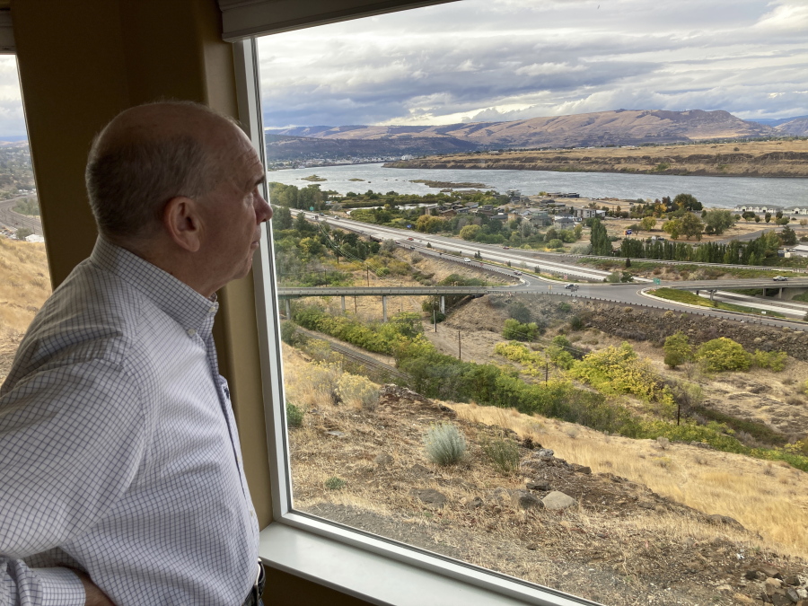 In this Tuesday, Oct. 5, 2021, photo, The Dalles Mayor Richard Mays looks at the view of his town and the Columbia River from his hilltop home in The Dalles, Oregon. Mays helped negotiate a proposal by Google to build new data centers in the town. The data centers require a lot of water to cool their servers, and would use groundwater and surface water, but not any water from the Columbia River.