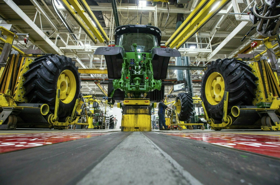 FILE - In this April 9, 2019, wheels are attach as workers assemble a tractor at John Deere's Waterloo, Iowa assembly plant. The vast majority of United Auto Workers union members rejected a contract offer from Deere & Co. Sunday, Oct. 10, 2021 that would have delivered at least 5% raises to the workers who make John Deere tractors and other equipment.