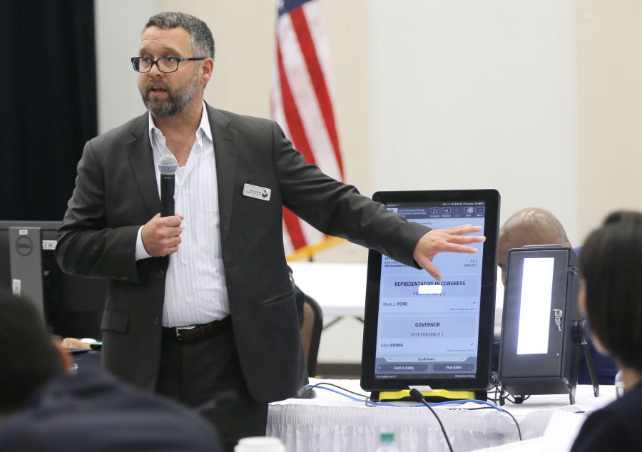 FILE - In this Aug. 30, 2018 file photo, Eric Coomer from Dominion Voting demonstrates his company's touch screen tablet that includes a paper audit trail at the second meeting of Secretary of State Brian Kemp's Secure, Accessible & Fair Elections Commission in Grovetown, Ga. Attorneys for President Donald Trump's re-election campaign, its onetime attorney Rudy Giuliani and conservative media figures asked a judge Wednesday, Oct. 13, 2021, to dismiss a defamation lawsuit by Coomer, a former employee of Dominion Voting Systems, who argues he lost his job after being named in false charges as trying to rig the 2020 election.