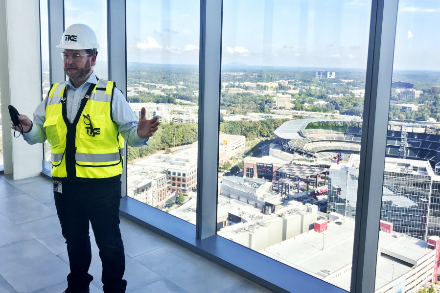 Kevin Lavallee, CEO of TK Elevators' North American operations, stands at the top of the company's new elevator testing facility, Wednesday, Oct. 13, 2021, that towers over the Atlanta Braves stadium and surrounding skyscrapers northwest of Atlanta. The 420-foot-tall tower is set to become fully operational early next year.