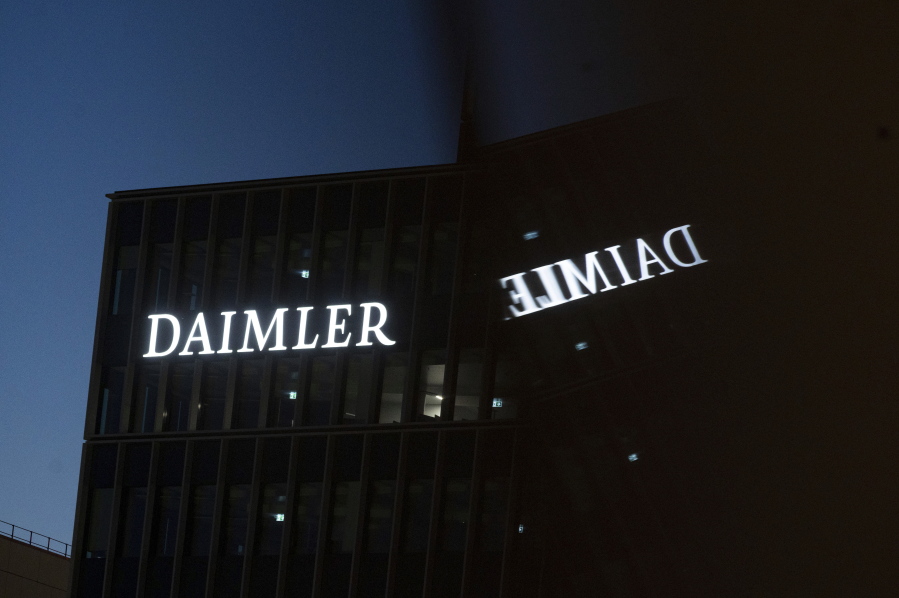 Daimler AG's corporate headquarters reflected in a window in Stuttgart, Germany, Thursday, Sept. 30, 2021. Shareholders in Daimler AG, maker of Mercedes-Benz luxury cars, have an extraordinary online meeting Friday, Oct. 1, 2021, on the spinoff of the company's truck business.