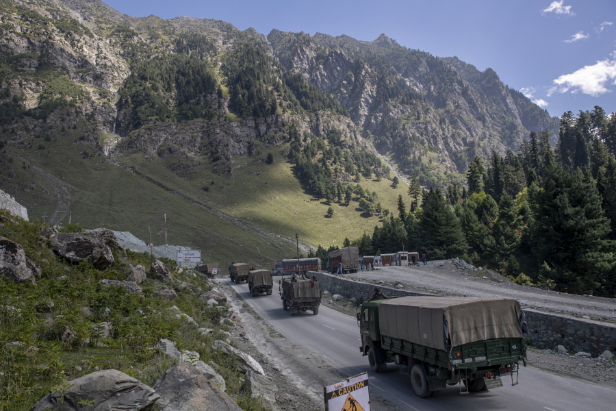 FILE - In this Sept. 9, 2020, file photo, an Indian army convoy moves on the Srinagar- Ladakh highway at Gagangeer, northeast of Srinagar, Indian-controlled Kashmir. India on Wednesday criticized China for its passage of a new land boundary law which it said could impact the two countries' border dispute amid tense ties. Both countries have stationed tens of thousands of soldiers backed by artillery, tanks and fighter jets along the de facto border called the Line of Actual Control in the Ladakh region.