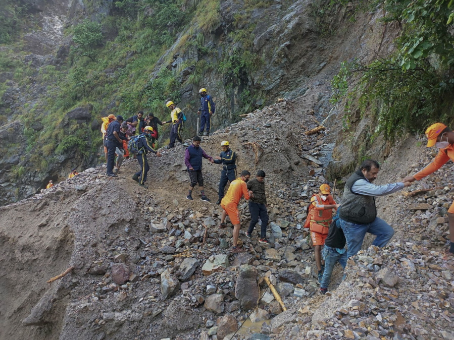 This photograph provided by India's National Disaster Response Force (NDRF) shows NDRF personnel rescuing civilians stranded following heavy rains at Chhara village near Nainital, Uttarakhand, Wednesday, Oct. 20, 2021. Nainital remained cut off from the rest of the state as roads leading to it were either blocked by landslides or washed away.