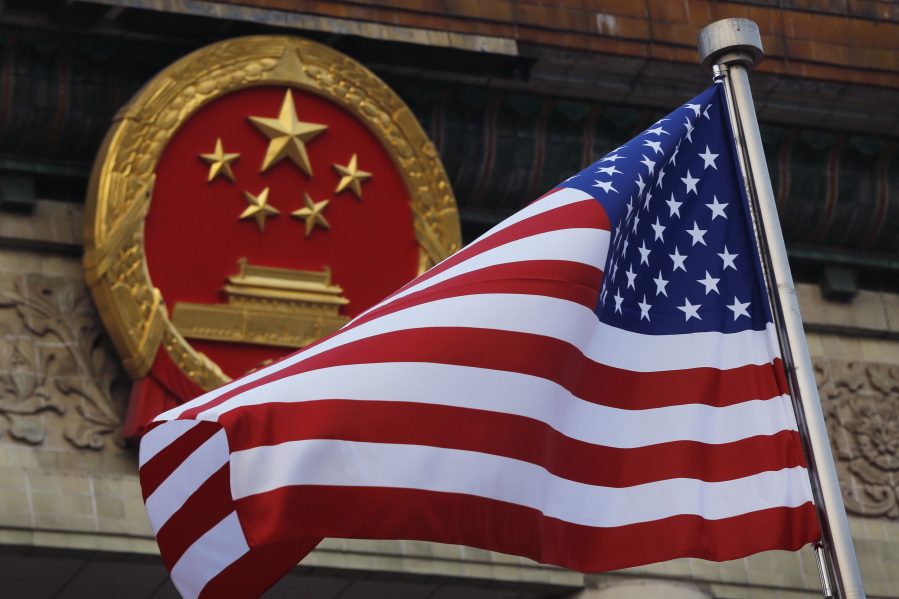 FILE - In this Nov. 9, 2017, file photo, an American flag is flown next to the Chinese national emblem during a welcome ceremony for visiting U.S. U.S. officials are issuing new warnings about China's ambitions in artificial intelligence and a range of advanced technologies that could eventually give Beijing a decisive military edge and possible dominance over health care and other essential sectors in America.