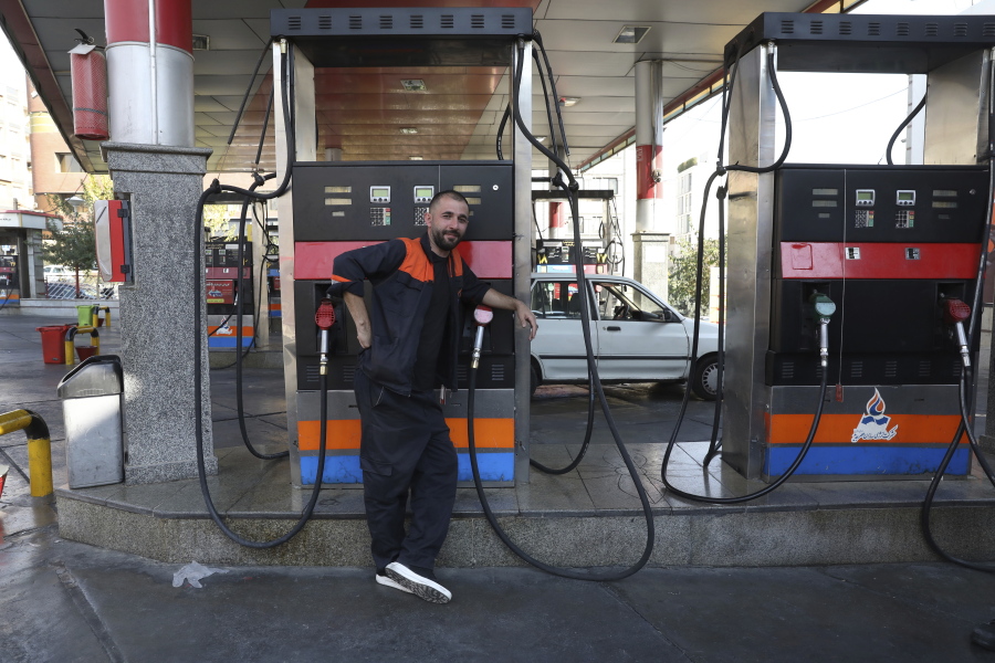 A worker leans against a gasoline pump that has been turned off, at a gas station in Tehran, Iran, Tuesday, Oct. 26, 2021. Gas stations across Iran on Tuesday suffered through a widespread outage of a system that allows consumers to buy fuel with a government-issued card, stopping sales. One semiofficial news agency referred to the incident as a cyberattack.