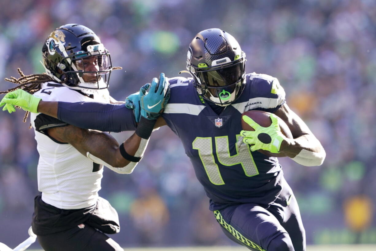 Seattle Seahawks' DK Metcalf (14) pushes off of Jacksonville Jaguars' Rayshawn Jenkins as he runs with the ball during the first half of an NFL football game, Sunday, Oct. 31, 2021, in Seattle. (AP Photo/Ted S.