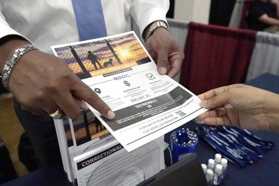 Curtis McCray, a Mississippi Department of Corrections recruiter, left, points out a positive testimonial to a job applicant during the Lee County Area Job Fair in Tupelo, Miss., Tuesday, Oct. 12, 2021. Employers representing a variety of manufacturing, production, service industry, medical and clerical companies attended the day long affair with an eye towards recruitment, hiring, training and retention. (AP Photo/Rogelio V.