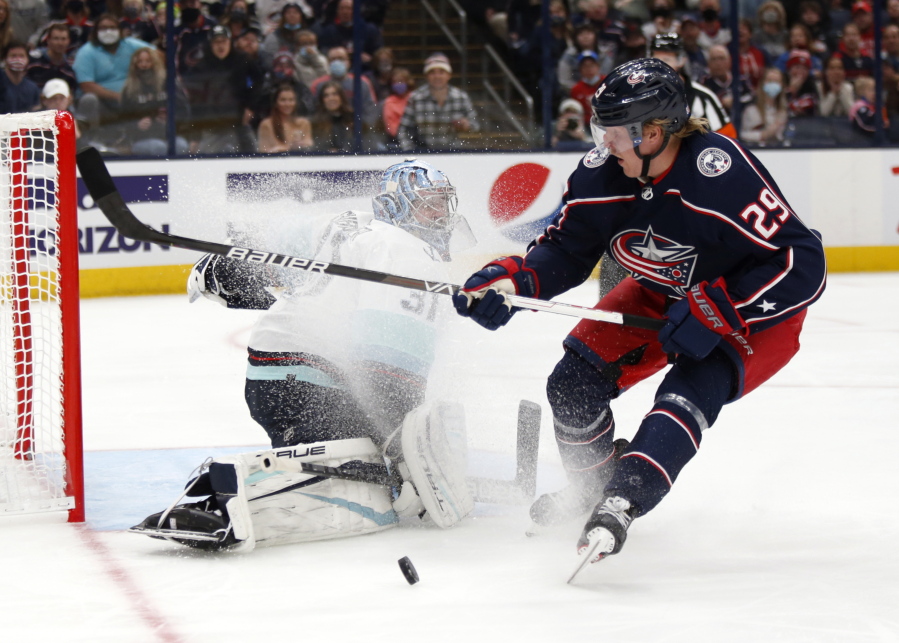 Seattle Kraken goalie Philipp Grubauer, left, stops a shot by Columbus Blue Jackets forward Patrik Laine during the second period of an NHL hockey game in Columbus, Ohio, Saturday, Oct. 16, 2021.