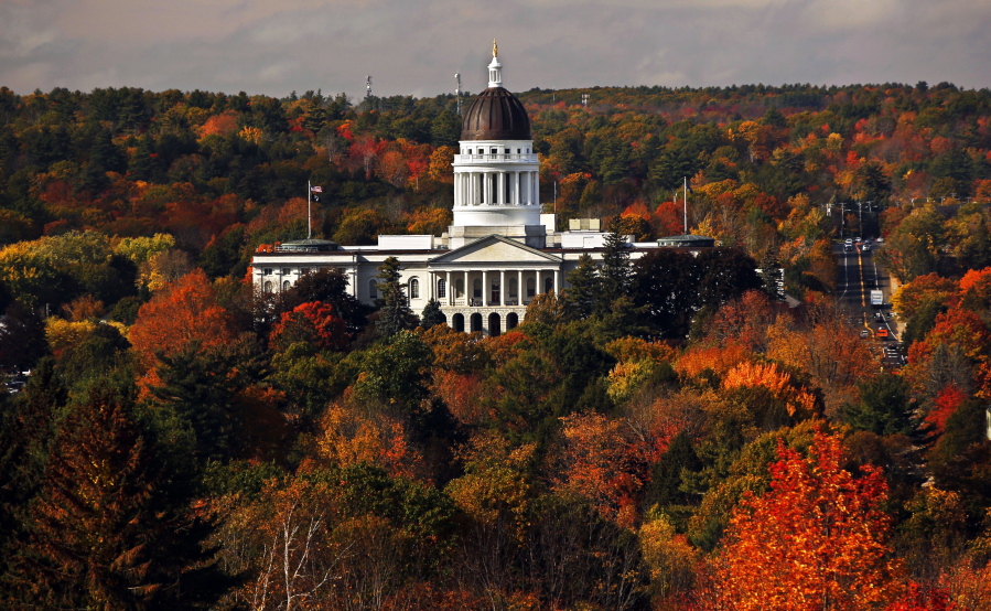 FILE - In this Oct. 23, 2017, file photo, the State House is surrounded by fall foliage in Augusta, Maine. Recent leaf-peeping seasons have been disrupted by weather conditions in New England, New York and elsewhere. Arborists and ecologists say the trend is likely to continue as the planet warms. (AP Photo/Robert F.