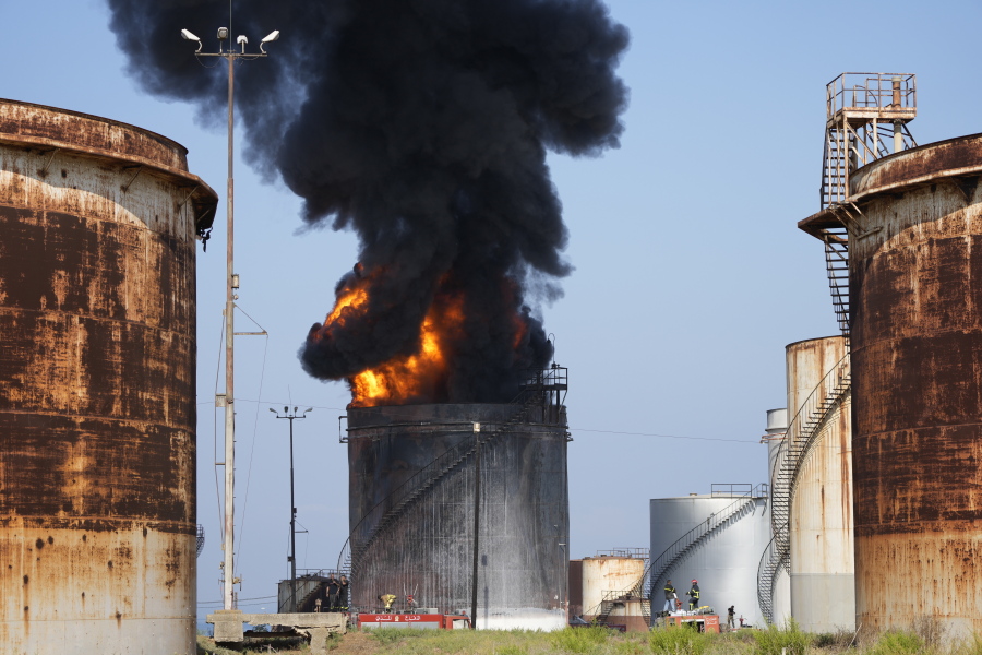 Firefighters work to extinguish a fire in an oil facility in the southern town of Zahrani, south of the port city of Sidon, Lebanon, Monday, Oct. 11, 2021. A huge fire broke out at an oil facility in southern Lebanon's coastal town of Zahrani, but the cause was not immediately known.