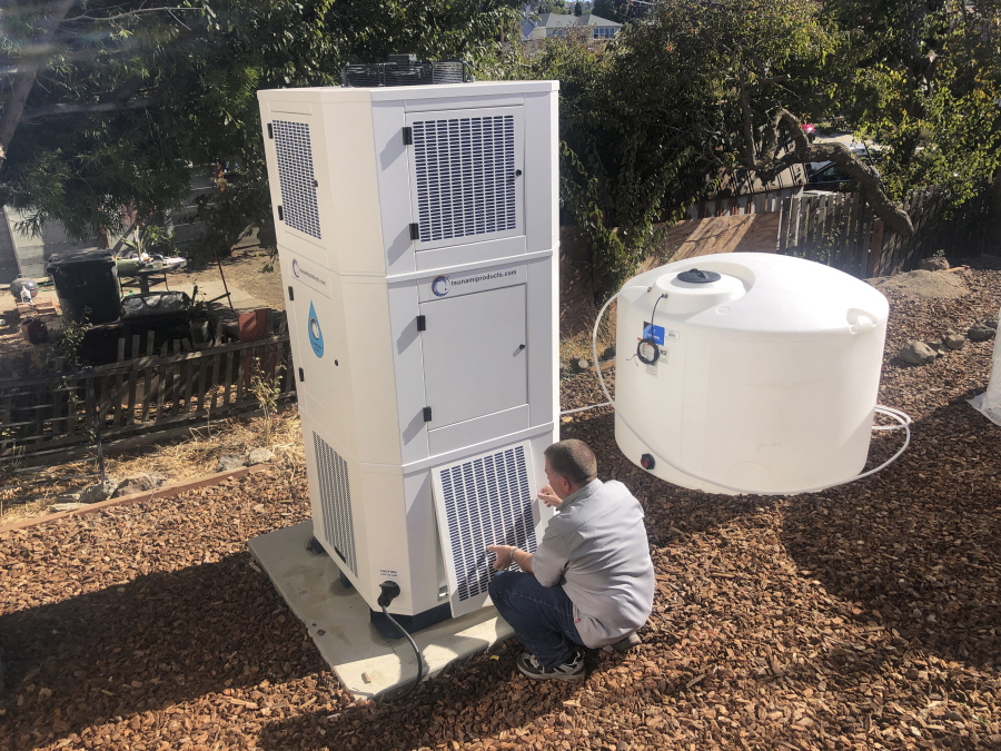 Ted Bowman, design engineer with Tsunami Products, installs an air-to-water unit in homeowner Don Johnson's backyard in Benicia, Calif.