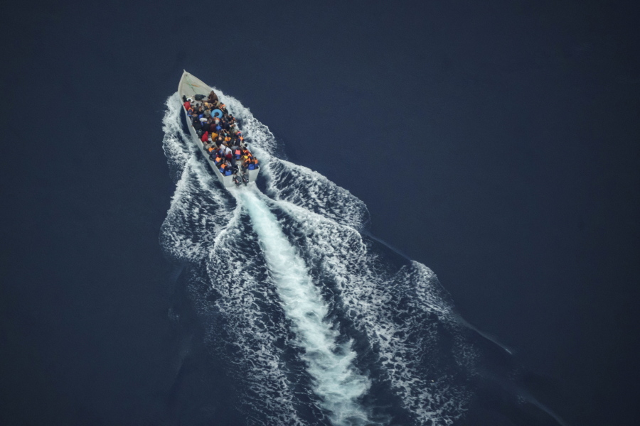 Migrants navigate on an overcrowded wooden boat in the Central Mediterranean Sea between North Africa and the Italian island of Lampedusa, Saturday, Oct. 2, 2021, as seen from aboard the humanitarian aircraft Seabird. At least 23,000 people have died or disappeared trying to reach Europe since 2014, according to the United Nations' migration agency. Despite the risks, many migrants say they'd rather die trying to reach Europe than be returned to Libya.