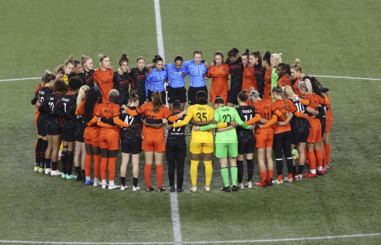 Portland Thorns and Houston Dash players, along with referees, gather at midfield Wednesday, in demonstration of solidarity with two former NWSL players who came forward with allegations of sexual harassment and misconduct against a former coach.