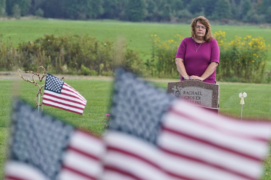 Sharon Grover stands over the grave of her daughter, Rachael, Tuesday, Sept. 28, 2021, at Fairview Cemetery in Mesopotamia, Ohio. Grover believes her daughter started using prescription painkillers around 2013 but missed any signs of her addiction as her daughter, the oldest of five children, remained distanced.