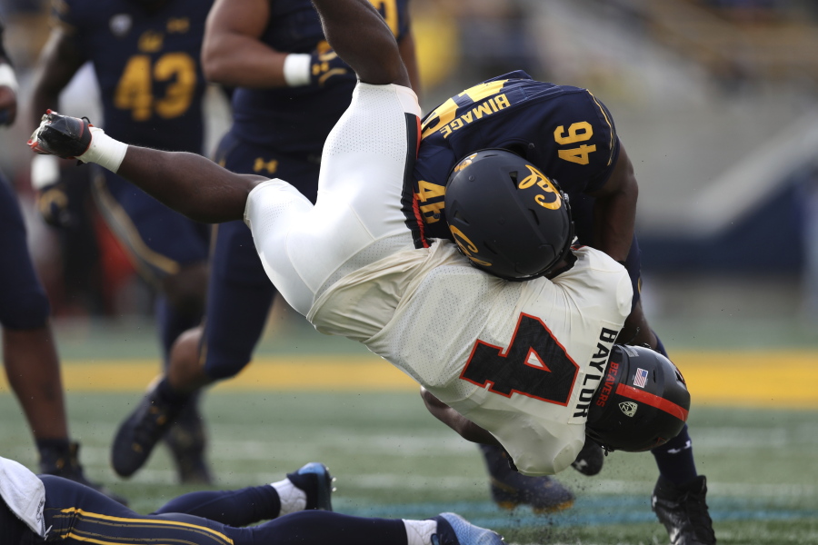 Oregon State running back B.J. Baylor (4) is tackled by California linebacker Marqez Bimage (46) during the first half of an NCAA college football game in Berkeley, Calif., Saturday, Oct. 30, 2021.