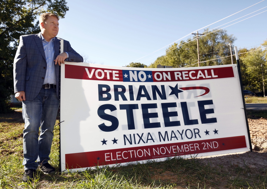 Brian Steele, Mayor of Nixa, is seen next to one of his campaign signs in Nixa, Missouri on Oct. 21,2021. Steele is facing a recall election on November 2  as a local conservative group has taken issue with some of the cities COVID-19 measures taken in the past year. (AP Photo/Bruce E.
