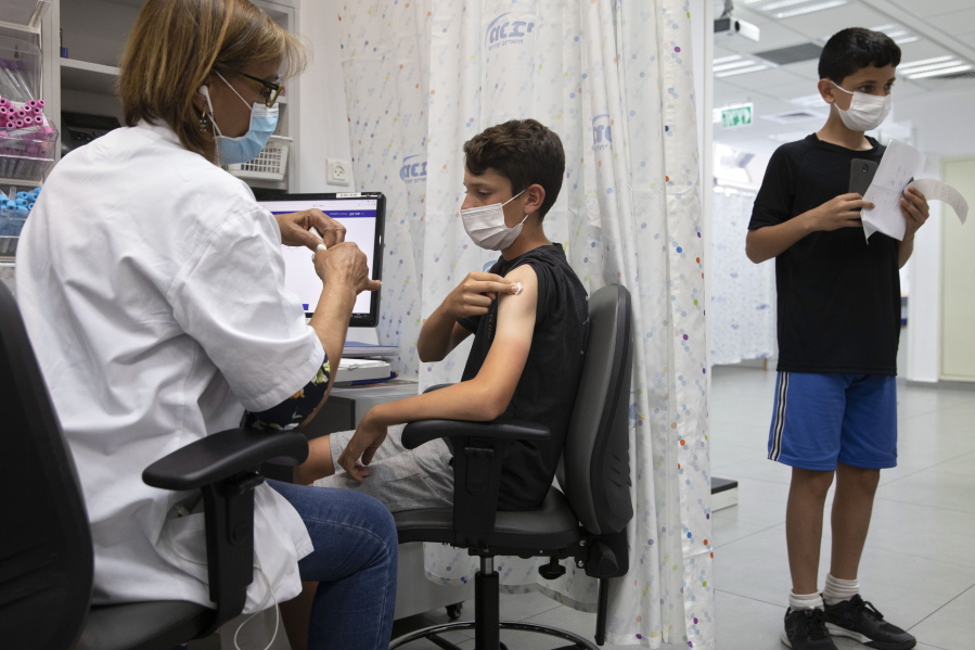 FILE - In this June 6, 2021 file photo, a youth receives a Pfizer-BioNTech COVID-19 vaccine in the central Israeli city of Rishon LeZion.