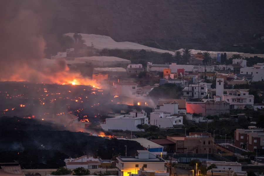 Lava flows from a volcano destroying houses at La Laguna neighbourhood on the Canary island of La Palma, Spain on Thursday Oct. 21, 2021. A second tongue of lava is expected to reach the Atlantic today and release more toxic gases into the atmosphere, an event which will lead to the home confinement of some nearby towns.